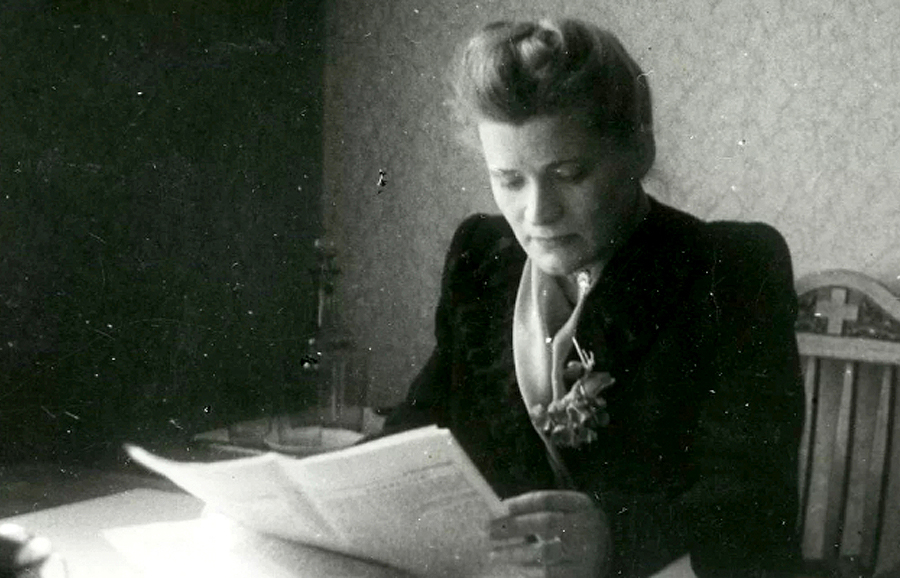 Herta Hanzena sēžot un lasot avīzi